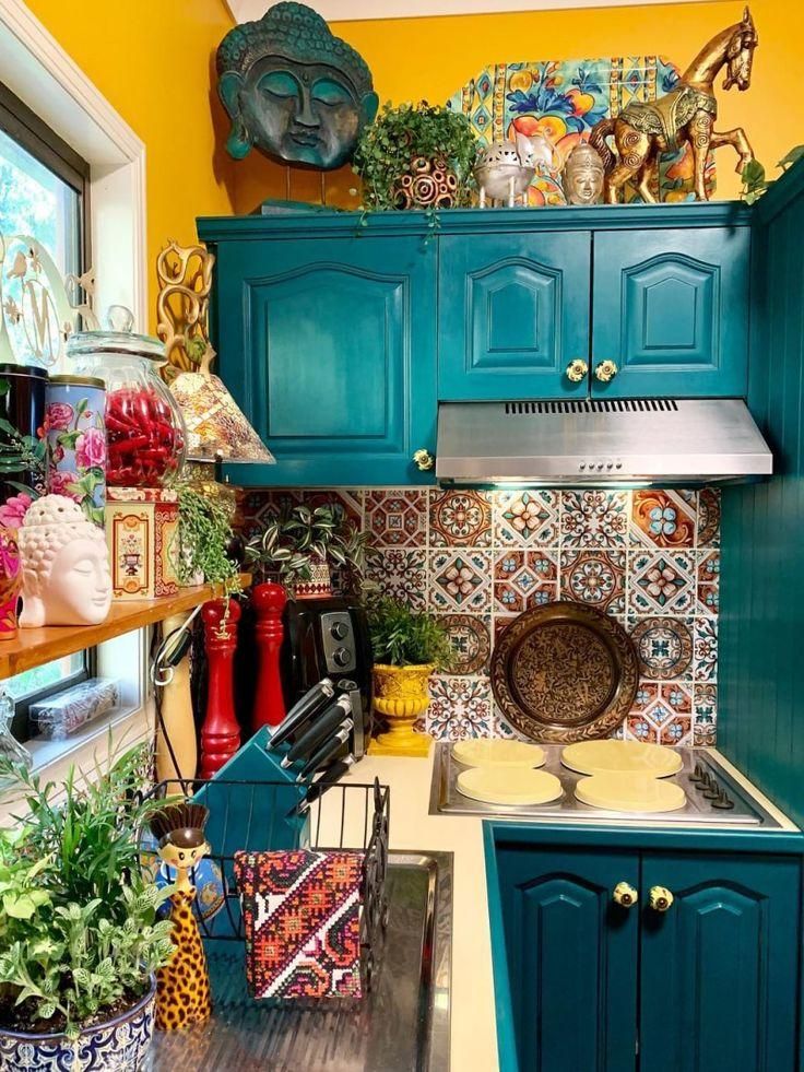 a kitchen with blue cabinets and colorful tile backsplashes, potted plants and pots on the counter