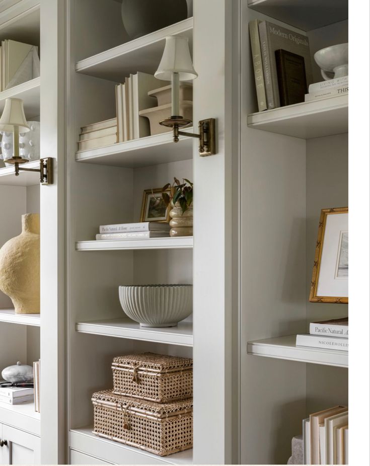 the shelves are filled with books, baskets and other items in white painted wood - paneled room