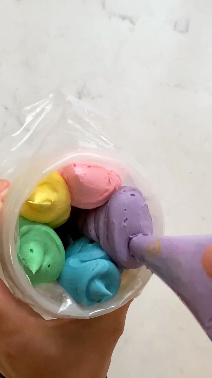 a person is holding a plastic container filled with colored play dough