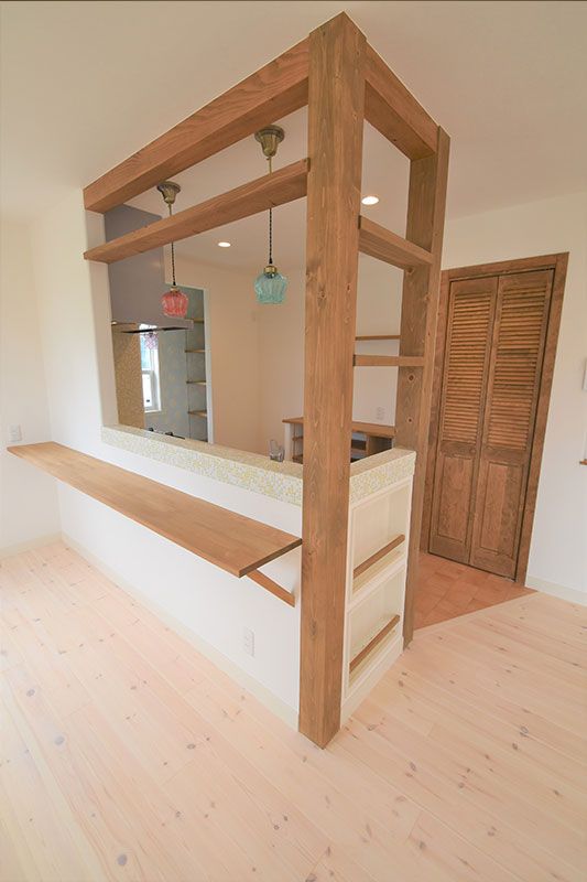 an empty room with wooden floors and shelves on the wall, in front of a mirror