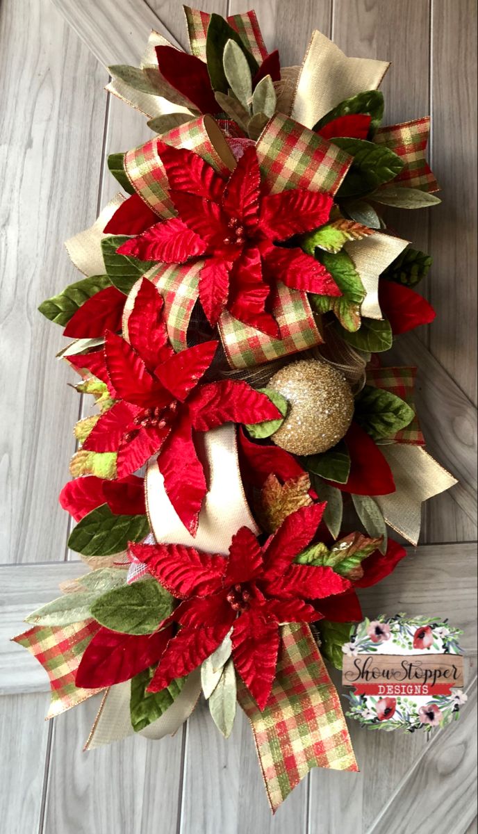 a christmas wreath with poinsettia and bells on the side of a door