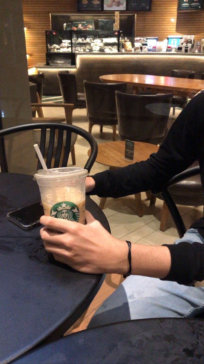 a man sitting at a table with a drink in his hand