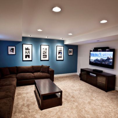 a living room filled with furniture and a flat screen tv mounted to the side of a wall