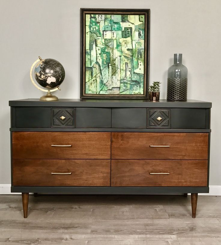 a dresser with two drawers and a painting on top