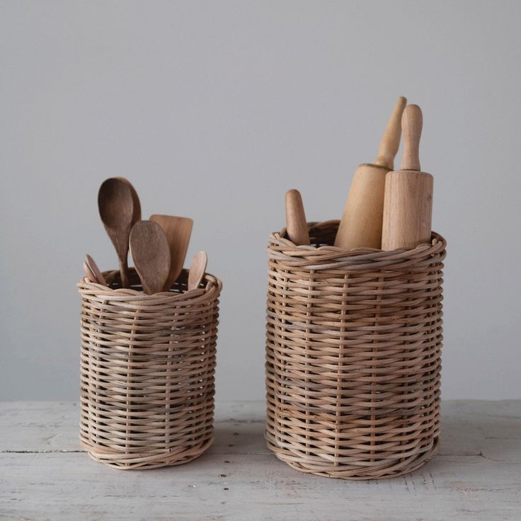 two wicker baskets with spoons and utensils in them