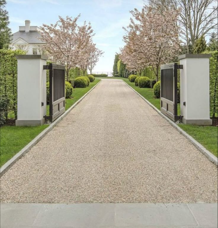 an open driveway with two gates leading into the distance