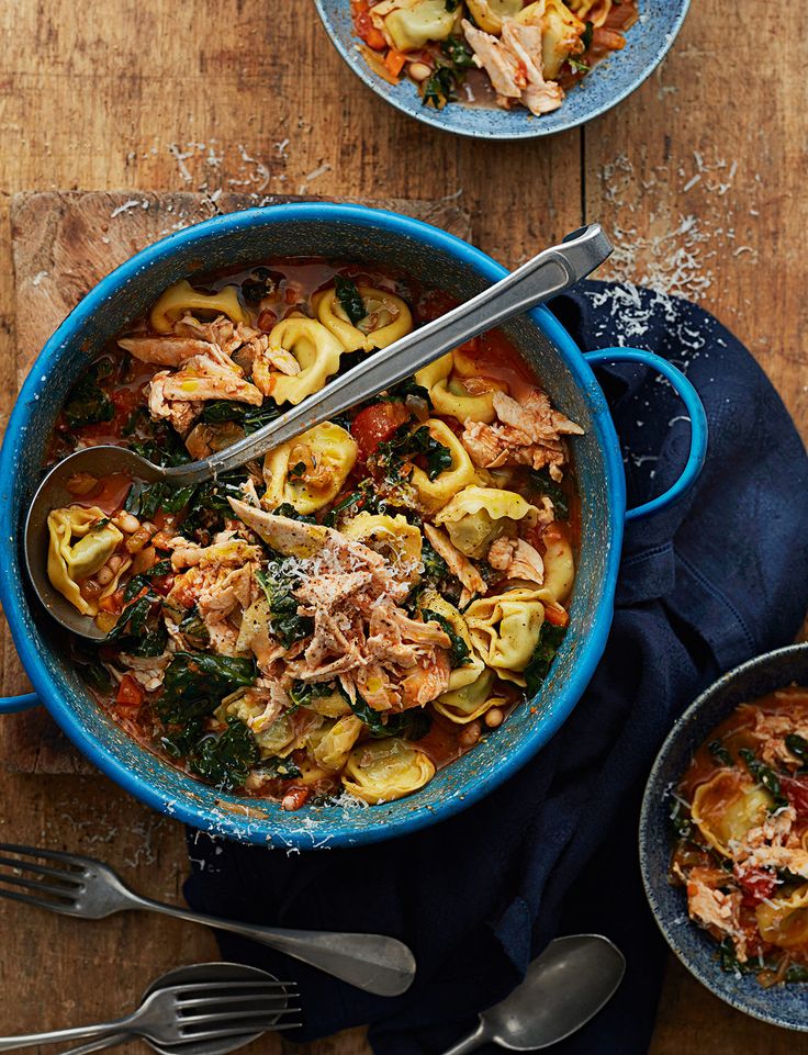 two bowls of pasta with meat, spinach and parmesan cheese on the side