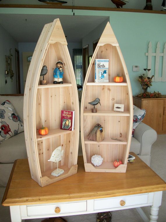 two wooden canoe shaped shelves sitting on top of a table