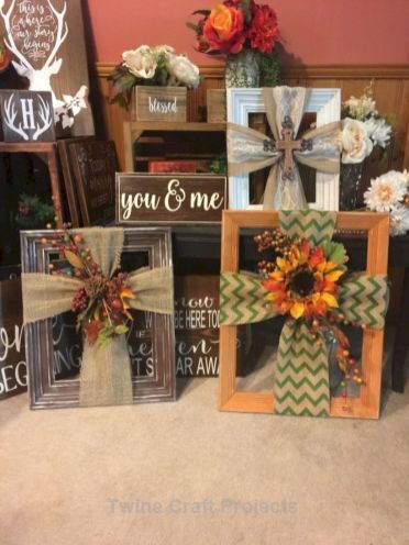 three wooden frames decorated with fall decorations and flowers are sitting on the floor in front of a fireplace