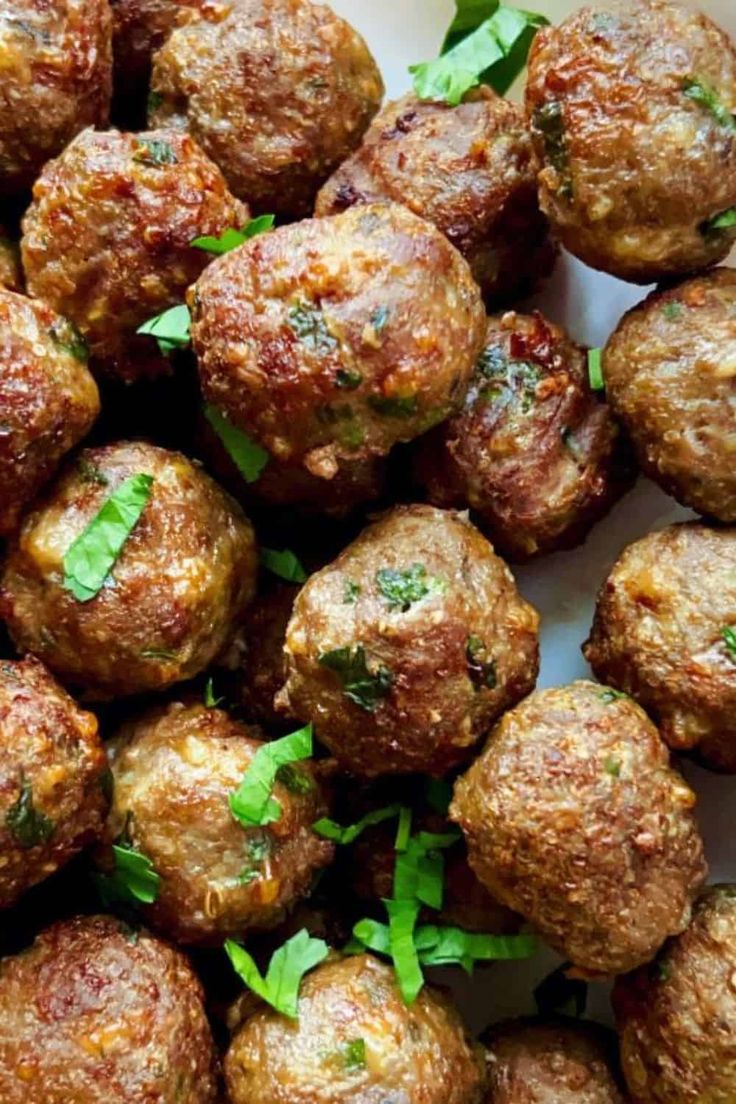 some meatballs with parsley on top of them