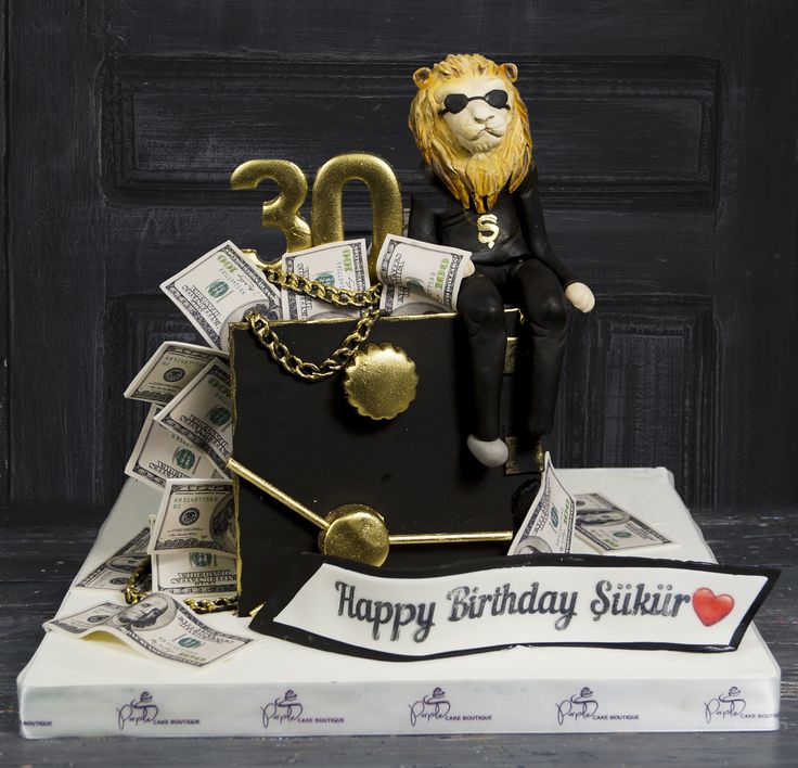 a birthday cake with money and a lion on top