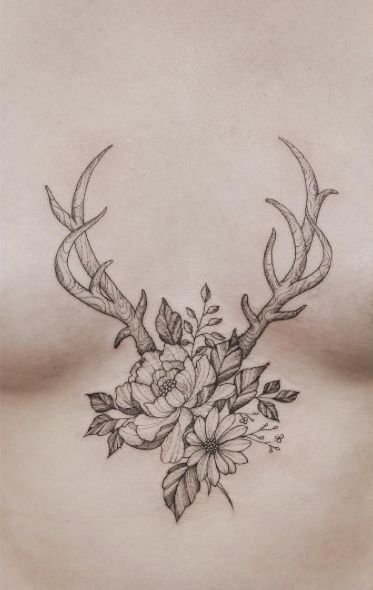 a woman's stomach with flowers and antlers on it