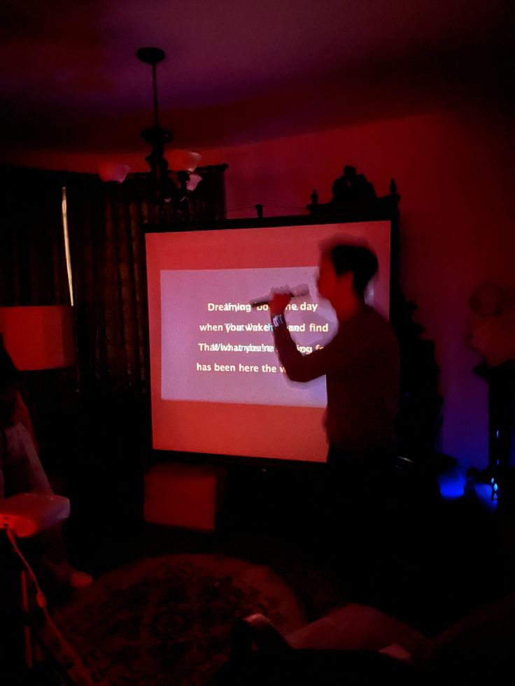 a man standing in front of a projection screen giving a presentation on the projector