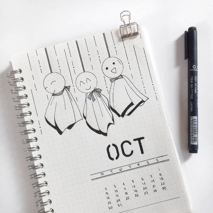 an open notebook with the word october written on it next to a marker and pen