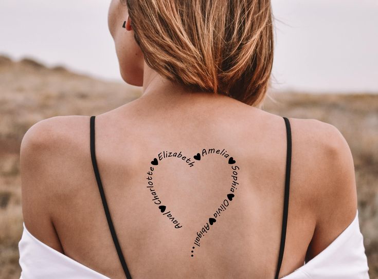 the back of a woman's shoulder with words written in heart shapes on it