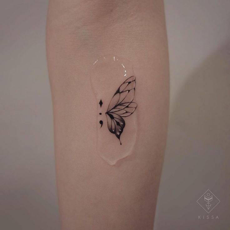 a small butterfly tattoo on the right side of the leg, it is black and white