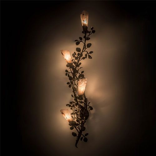 a wall mounted candle holder with flowers and leaves in the shape of candles on it