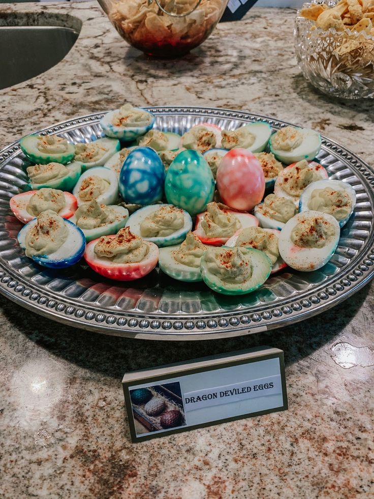 an assortment of deviled eggs on a platter with a name plate next to it