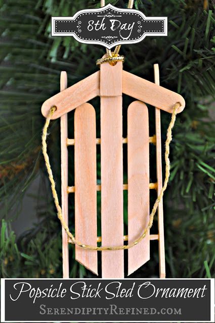 popsicle stick ornament hanging from a christmas tree with the words popsicle stick ornament on it