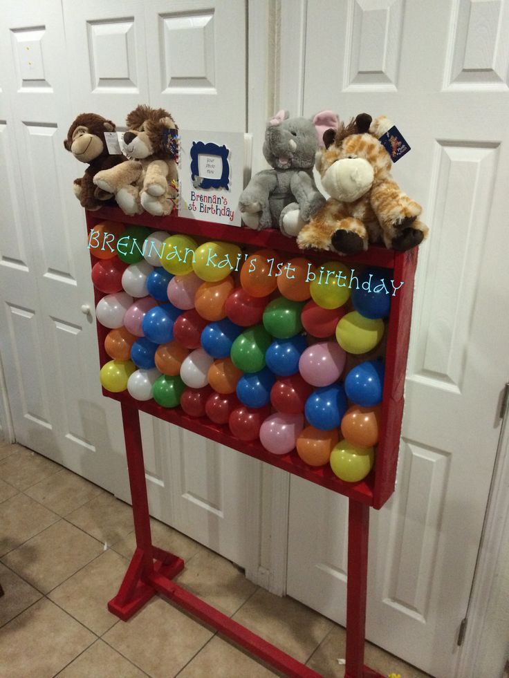 there are stuffed animals sitting on top of a birthday card holder that is filled with balloons