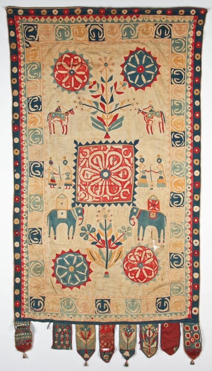 an old rug with horses and flowers on the front, fringes hanging from it's sides