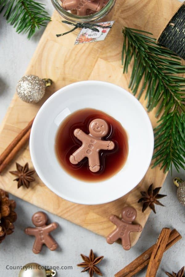 a white bowl filled with liquid next to cinnamon sticks and star anisette decorations