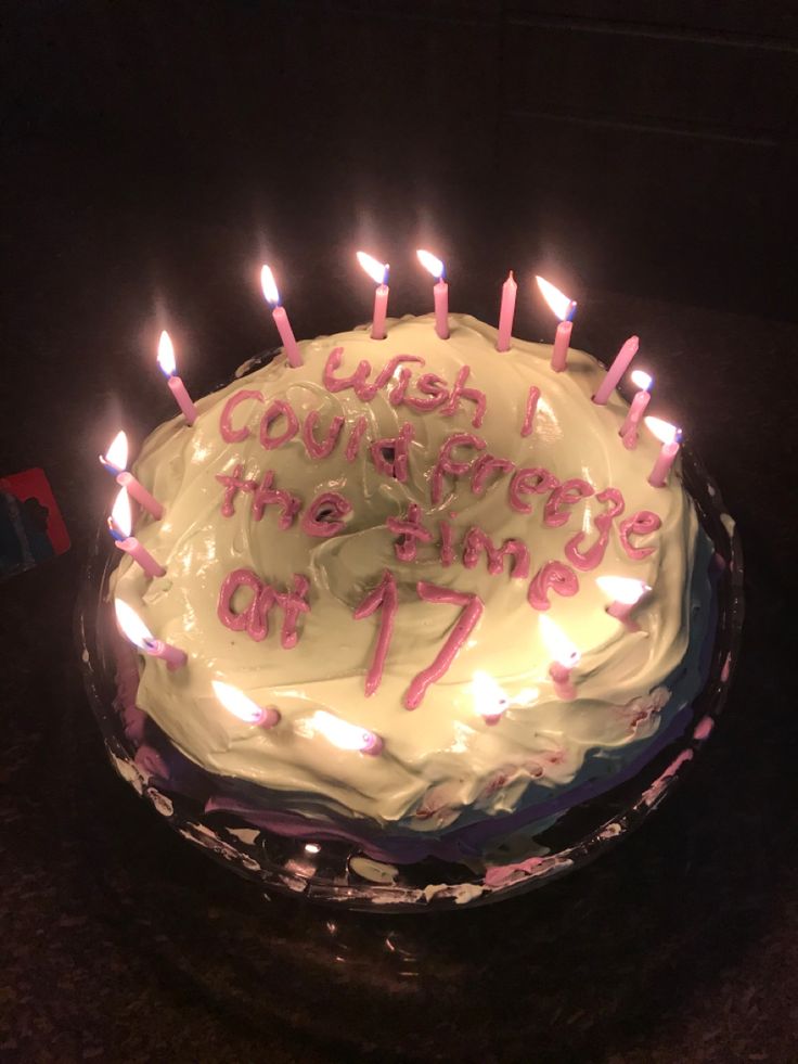 a birthday cake with white frosting and lit candles