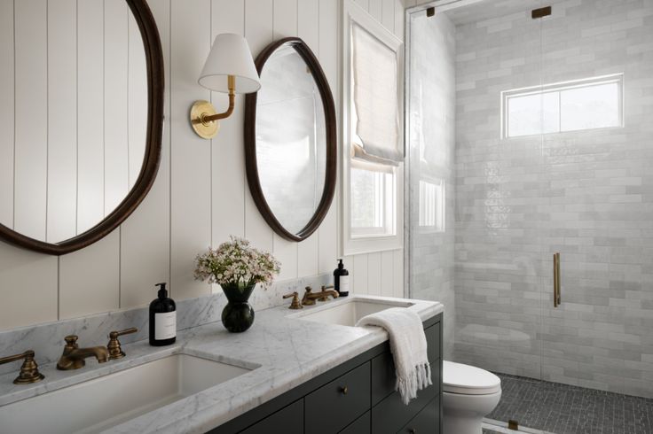 a bathroom with two sinks and mirrors in it