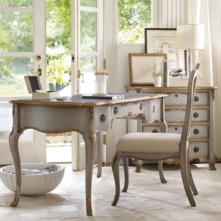 an elegant desk and chair in a white room