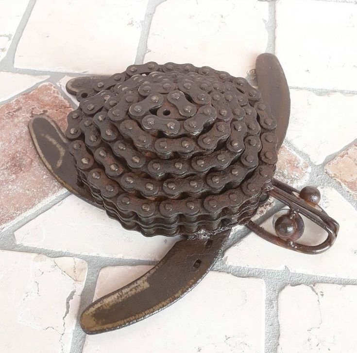 a close up of a bike chain on a tile floor with a pair of scissors