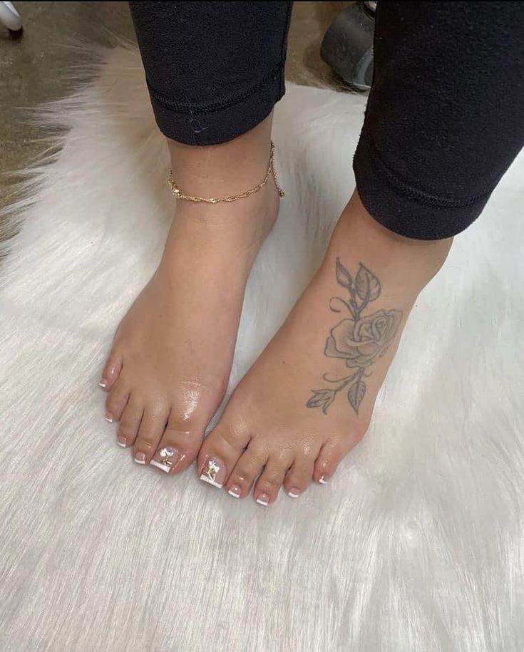 a woman's foot with a flower tattoo on her left leg and white fur