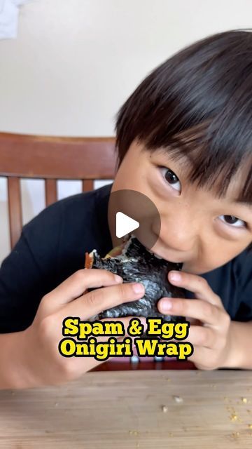 a young boy eating an egg omgii wrap at a table with the caption spam & egg omgii wrap