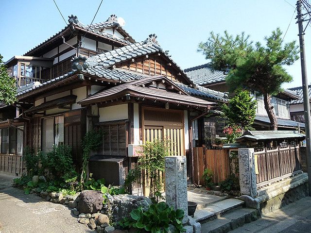 an old japanese house with stone steps leading up to it