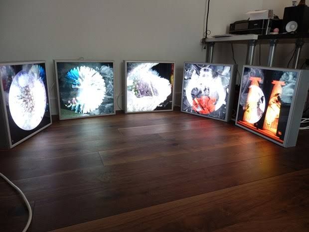 four televisions sitting on top of a wooden floor