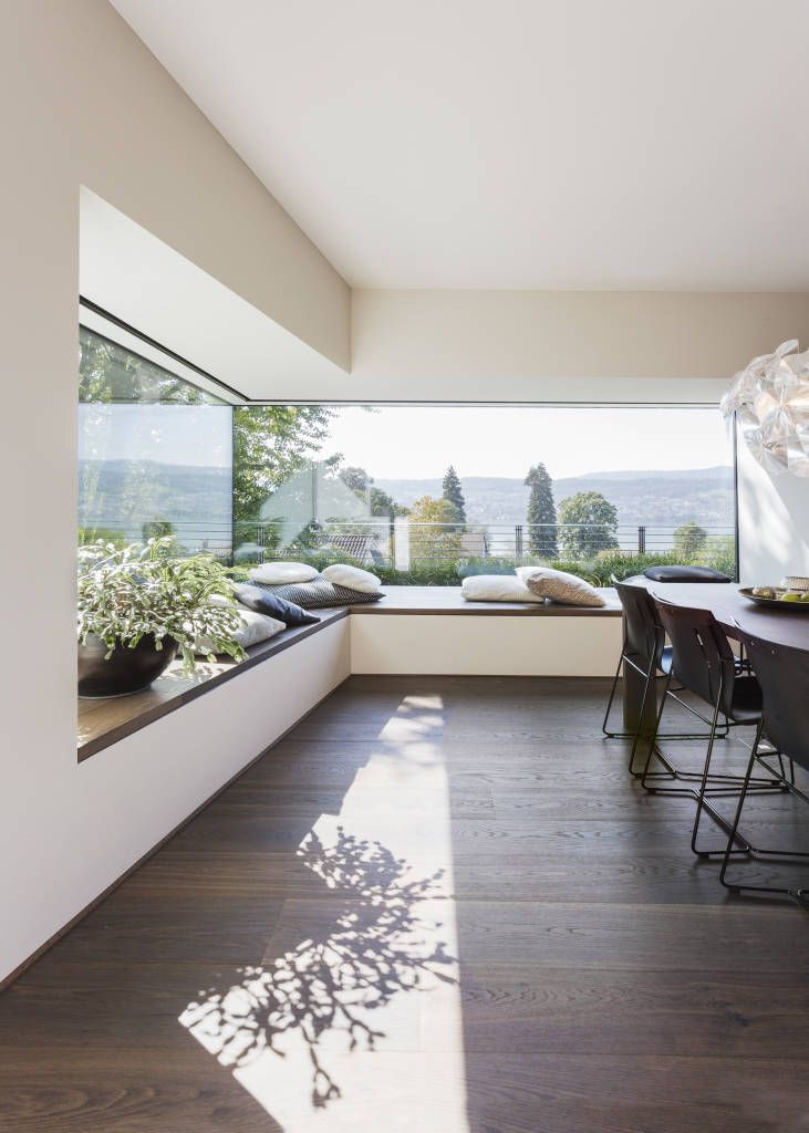 an instagram photo of a dining room and living room with windows overlooking the water