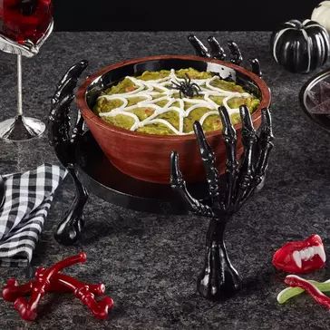 a bowl filled with food sitting on top of a table next to two wine glasses