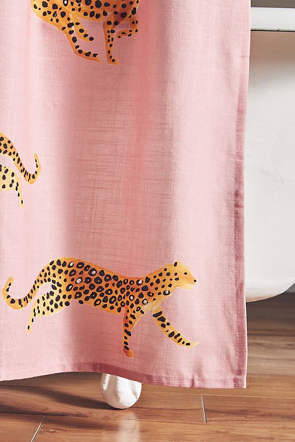 a pink shower curtain with yellow cheetah on it and black dots in the background