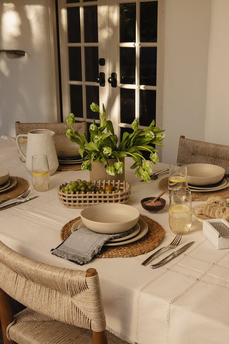 a table set for two with plates, bowls and utensils