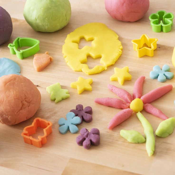 there are many different types of play doughs on the wooden table, including flowers and stars