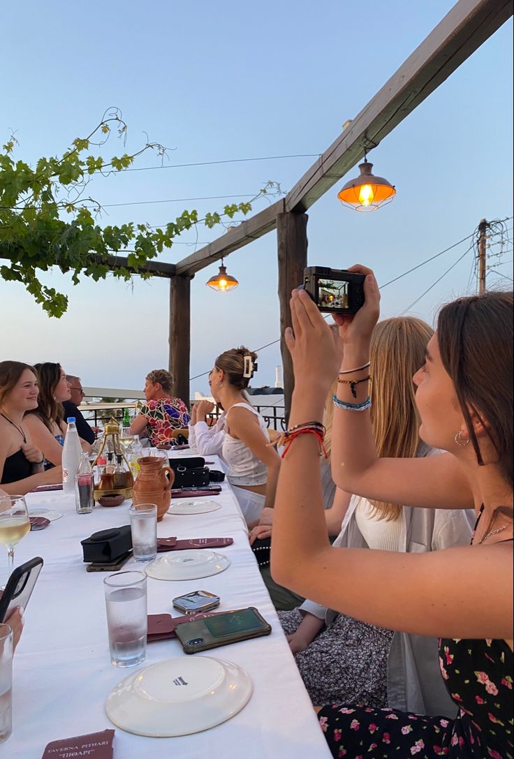 a group of people sitting at a table taking pictures