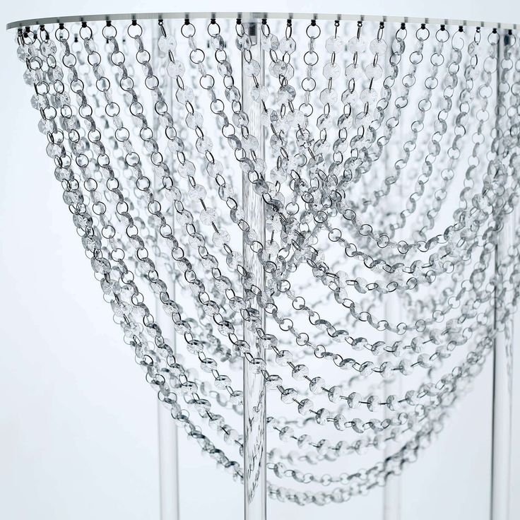 chains hang from the ceiling in front of a white wall