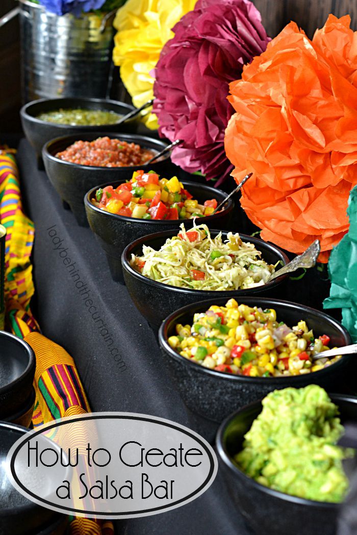 bowls filled with food sitting on top of a table covered in tissue paper pom poms