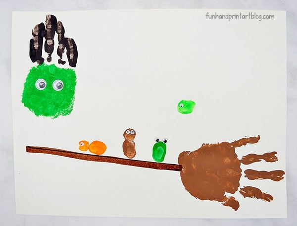 a child's handprint is shown on a piece of paper that has birds and leaves painted on it