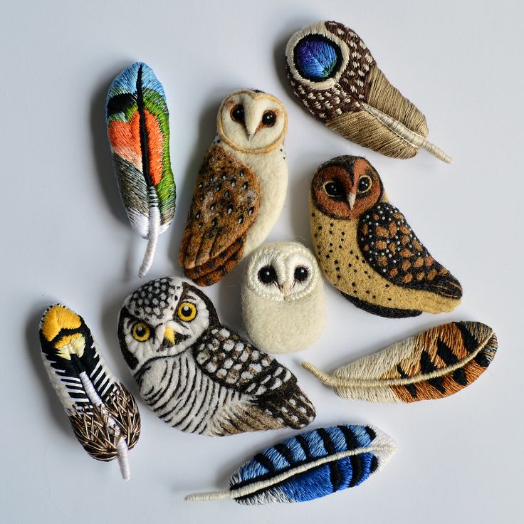 an assortment of different colored owls sitting next to each other on top of a white surface