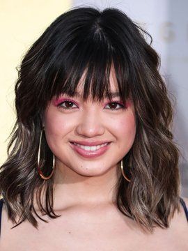 a close up of a person wearing large hoop earrings