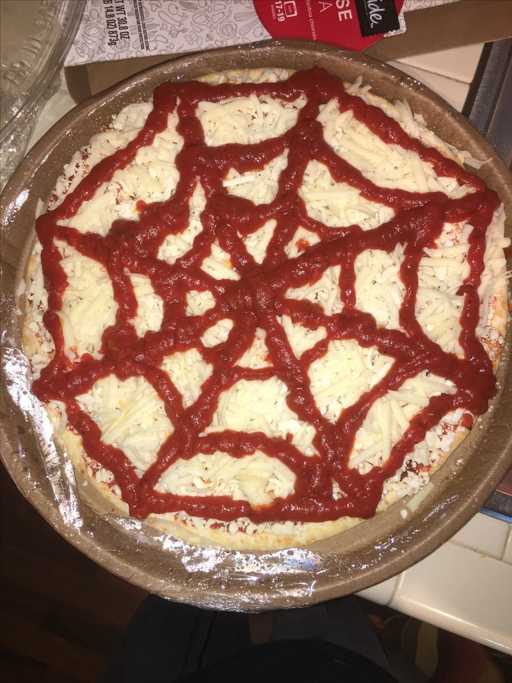 an uncooked pizza sitting on top of a pan covered in cheese and sauce