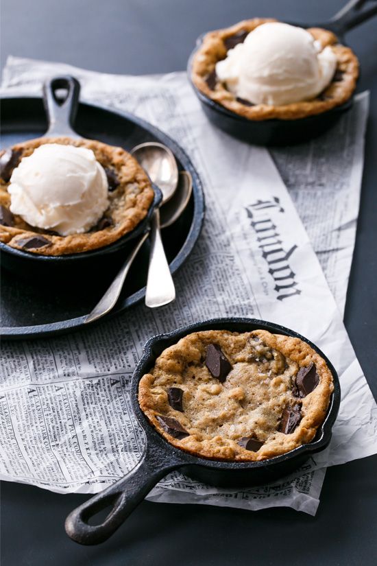 two small cast iron skillets with ice cream and chocolate chip pies in them