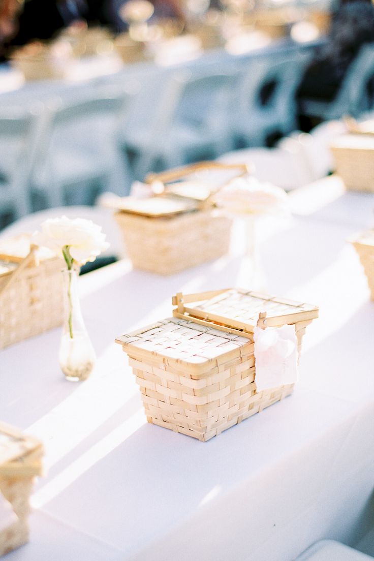 the table is set up with baskets and flowers for guests to sit down in their seats