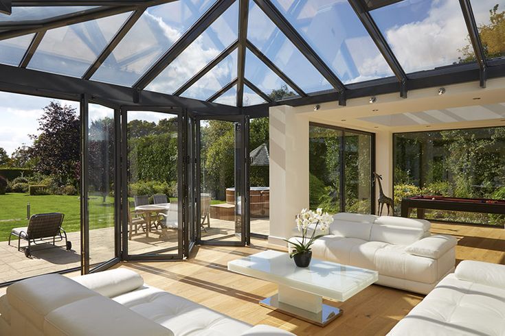 a living room filled with white furniture and lots of glass walls on top of it