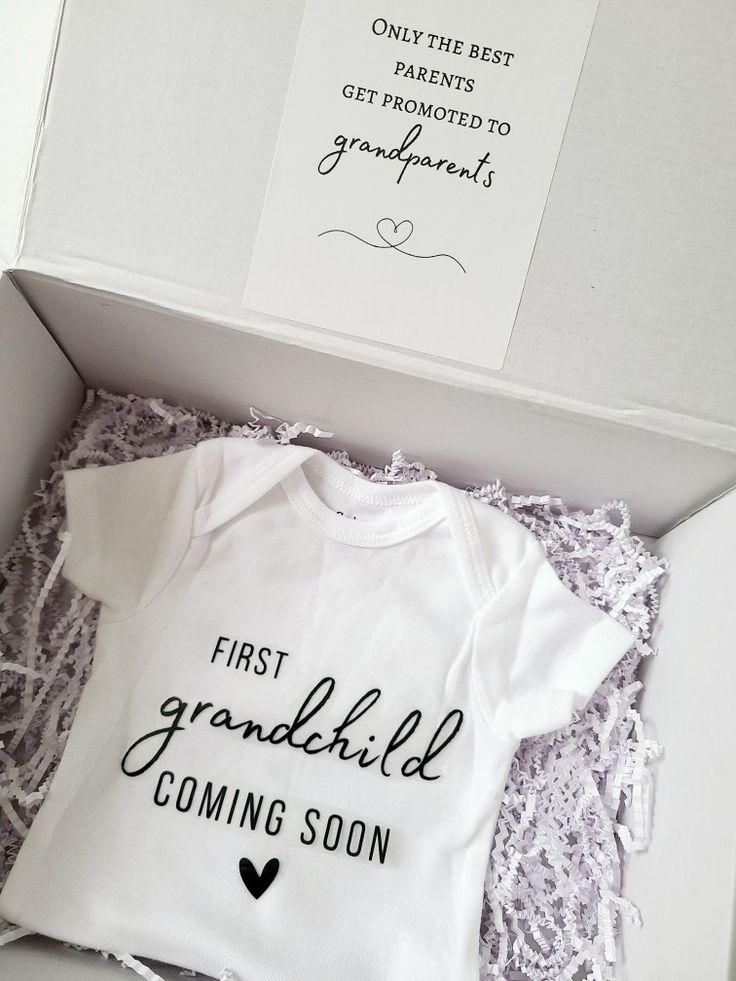 a baby's first grandchild coming soon gift set in a white box with black lettering